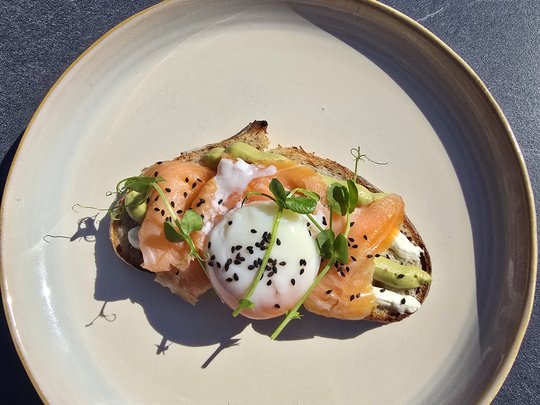 Willkommen in Olang: Hotel Christoph Toast mit Lachs, pochiertem Ei, Avocado und Sprossen auf einem Teller