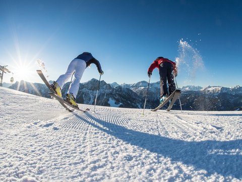 Your Plan de Corones/Kronplatz hotel on the slopes Two skiers starting a run on a sunny snowy mountain slope