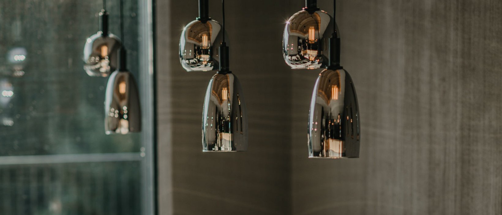 The right room for your Lago di Braies/Pragser Wildsee holiday A set table with cups under modern pendant lights in a restaurant.