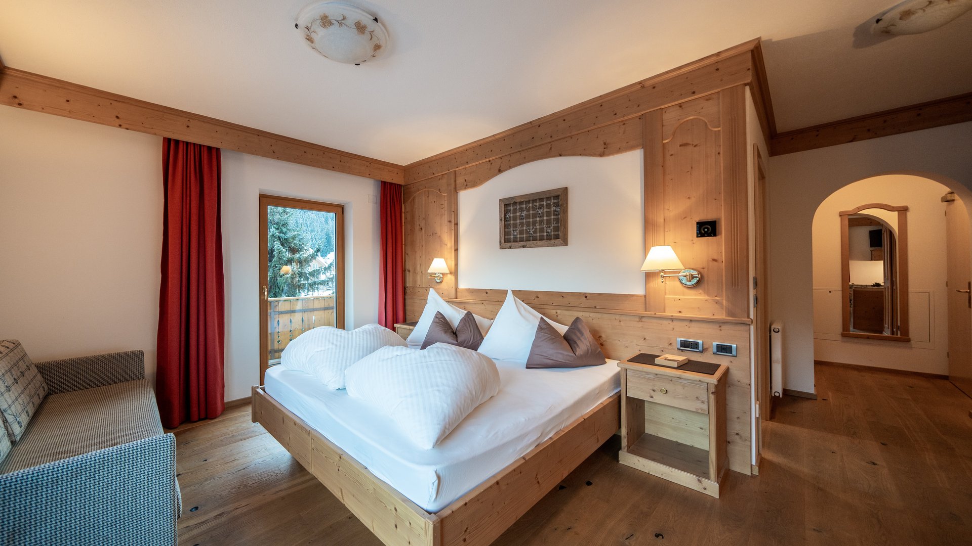 Willkommen in Olang: Hotel Christoph Gemütliches Schlafzimmer mit Holzmöbeln, Doppelbett und Balkon