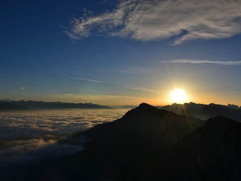 Standardzimmer Hotel Christoph Sonnenuntergang über wolkenbedeckten Bergen mit blauem Himmel