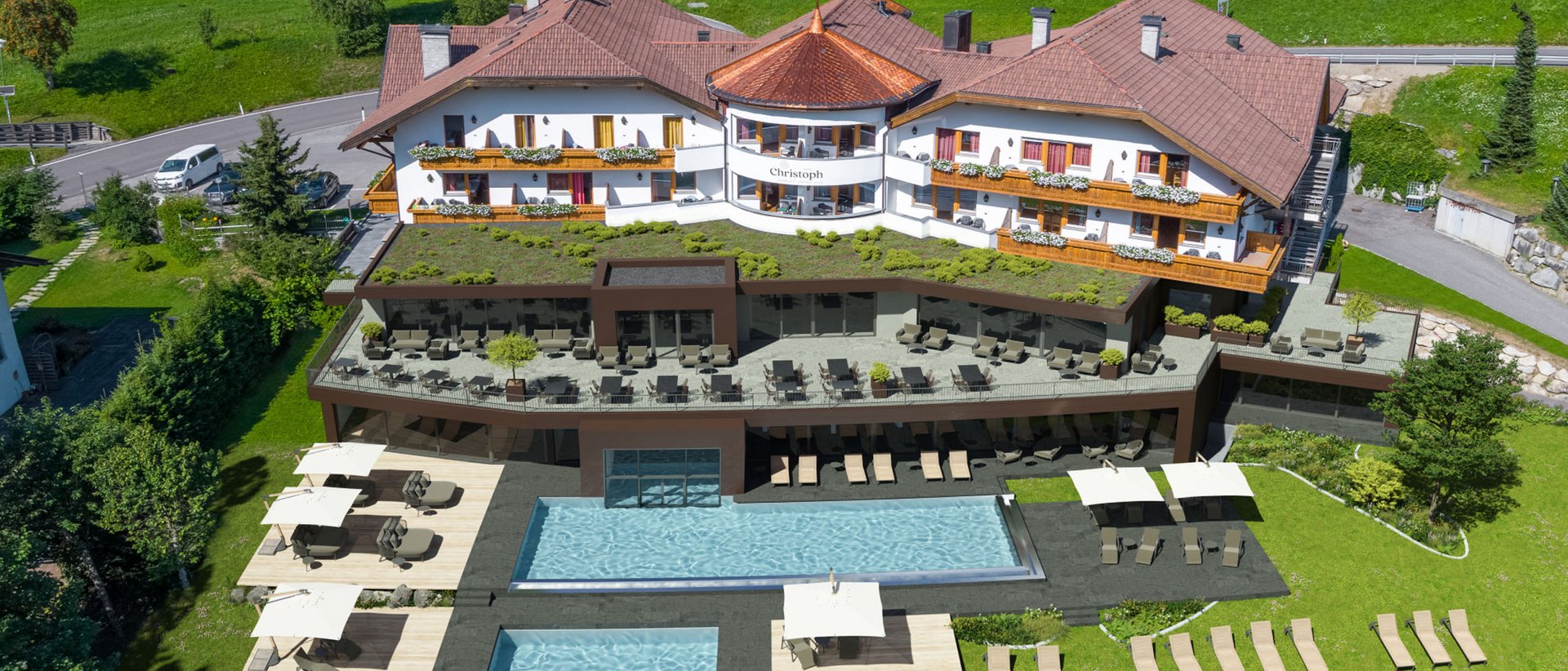 Warum Hotels im Pustertal ein Volltreffer für Ihren Traumurlaub sind Hotelgebäude mit Pool und Sonnenterrassen in grüner Landschaft
