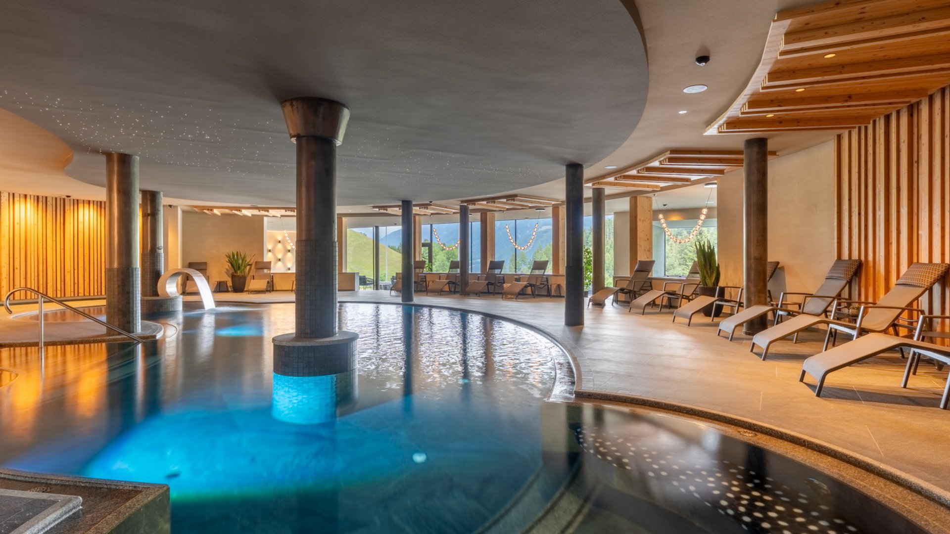Willkommen in Olang: Hotel Christoph Innenansicht eines modernen Wellnesspools mit Liegestühlen und Panoramafenstern