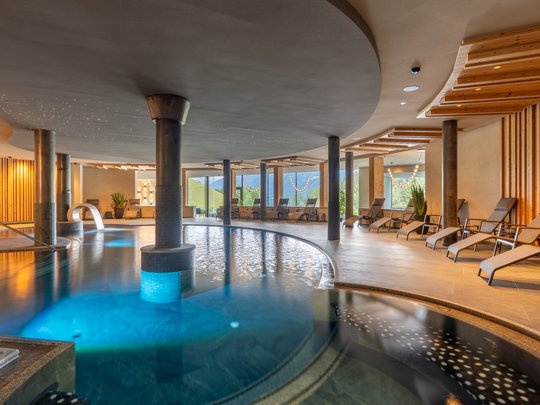 Willkommen in Olang: Hotel Christoph Innenansicht eines modernen Wellnesspools mit Liegestühlen und Panoramafenstern