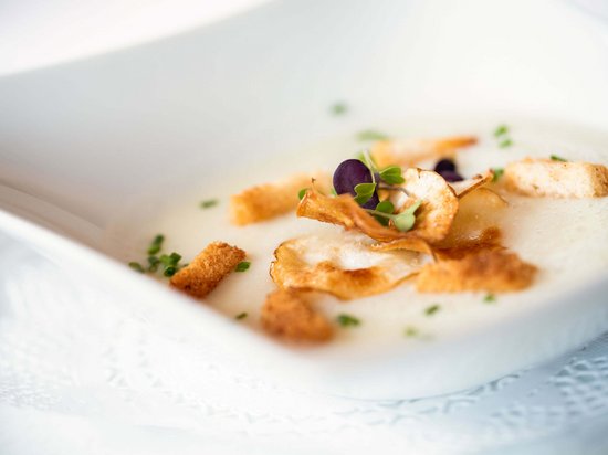 Leichte Wanderung am Kronplatz Cremige Suppe mit Croûtons und Kräutern in weißer Schale