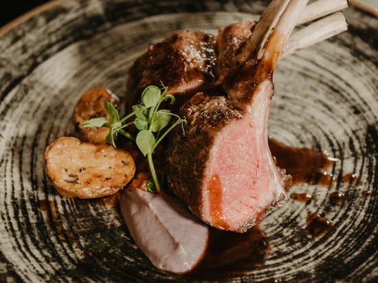 The right room for your Lago di Braies/Pragser Wildsee holiday Grilled lamb chops with potatoes and sauce on a decorative plate