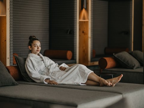 Standardzimmer Hotel Christoph Frau entspannt in Bademantel auf Lounge-Sofa in modernem Raum