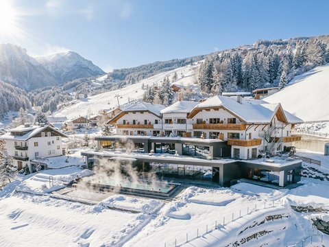 Willkommen in Olang: Hotel Christoph Schneebedecktes Hotel mit beheiztem Außenpool in den Bergen bei sonnigem Wetter