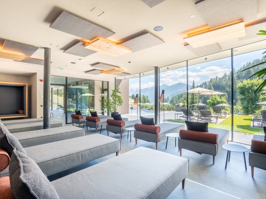 Willkommen in Olang: Hotel Christoph Moderner Ruheraum mit Liegen und Panoramafenstern zur Berglandschaft